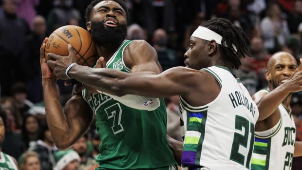Dec 25, 2021; Milwaukee, Wisconsin, USA; Milwaukee Bucks guard Jrue Holiday (21) fouls Boston Celtics guard Jaylen Brown (7) during the fourth quarter at Fiserv Forum. Mandatory Credit: Jeff Hanisch-USA TODAY Sports